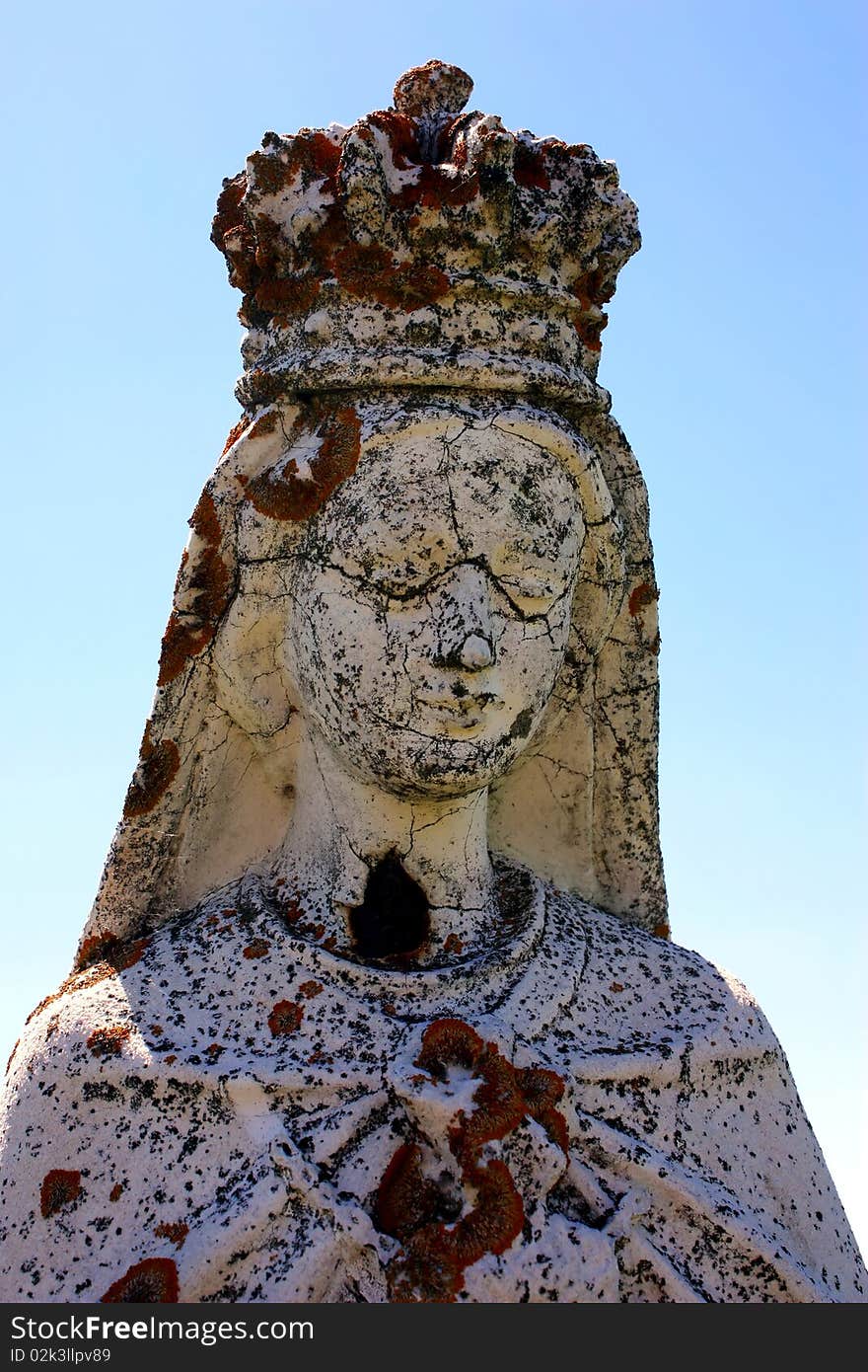 Religious statue closeup in cemetery on blue sky