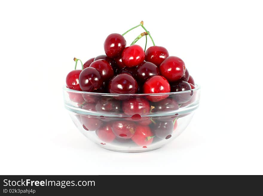 Heap of sweet cherries in a glass bowl isolated on white