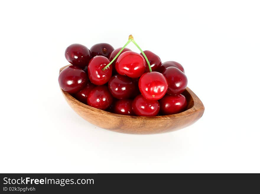 Sweet cherries in a wood bowl, isolated on white