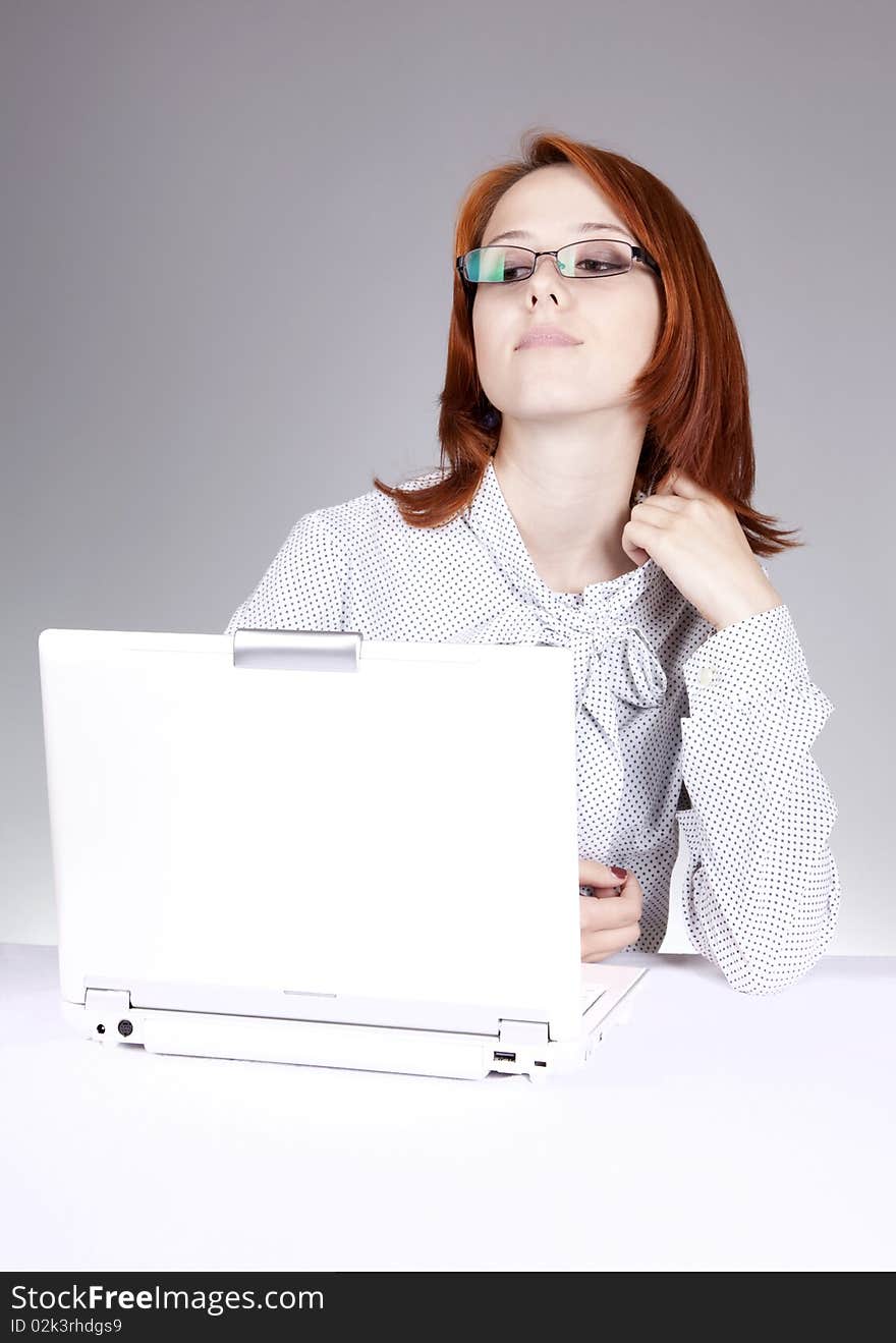 Red-haired girl with white notebook. Studio shot.