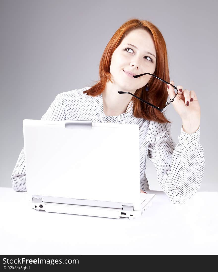 Red-haired girl with white notebook. Studio shot.