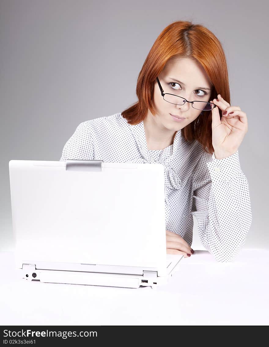 Red-haired girl with white notebook. Studio shot.