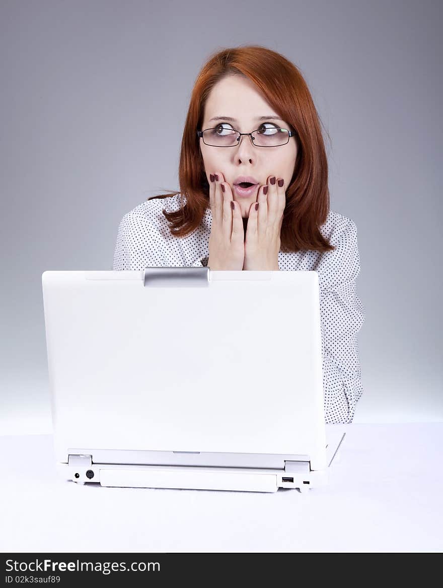 Red-haired girl with white notebook. Studio shot.