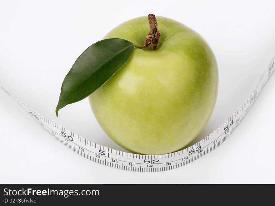 Green apple and measuring tape on a white background