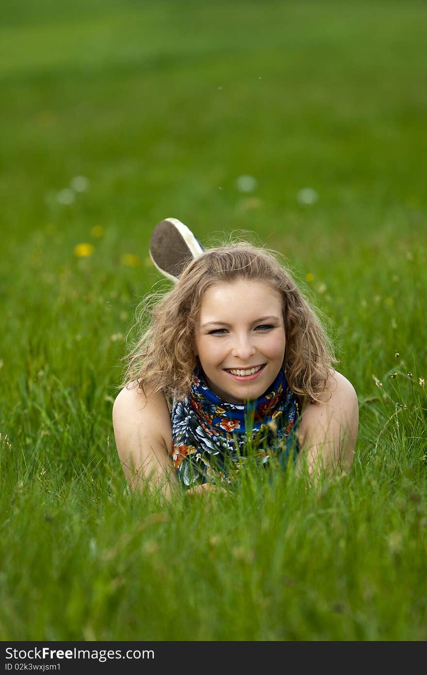 Young girl lay in the grass outdoor smiling