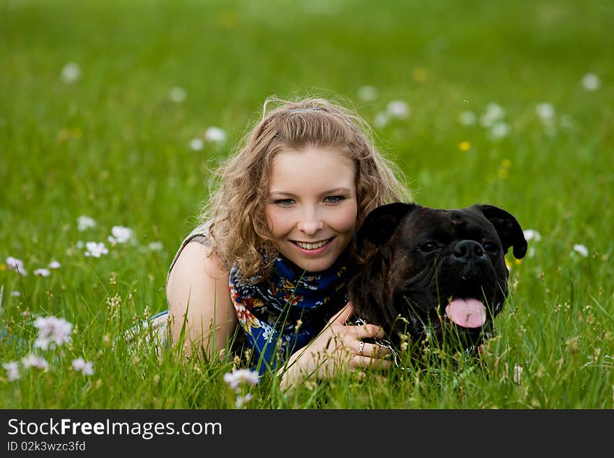 Young girl lay in the grass outdoor smiling with dog