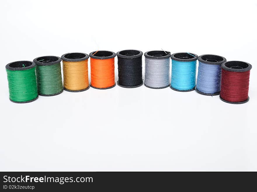 Colorful thread spools on a white background. Colorful thread spools on a white background.