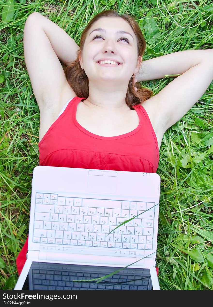 Beautiful attractive young girl on nature with laptop