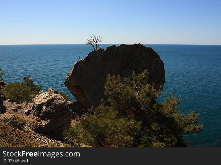 Mountain and sea landscape east of crimea. The mountains and rocks, covered with juniper and pine. Blue sea. Mountain and sea landscape east of crimea. The mountains and rocks, covered with juniper and pine. Blue sea