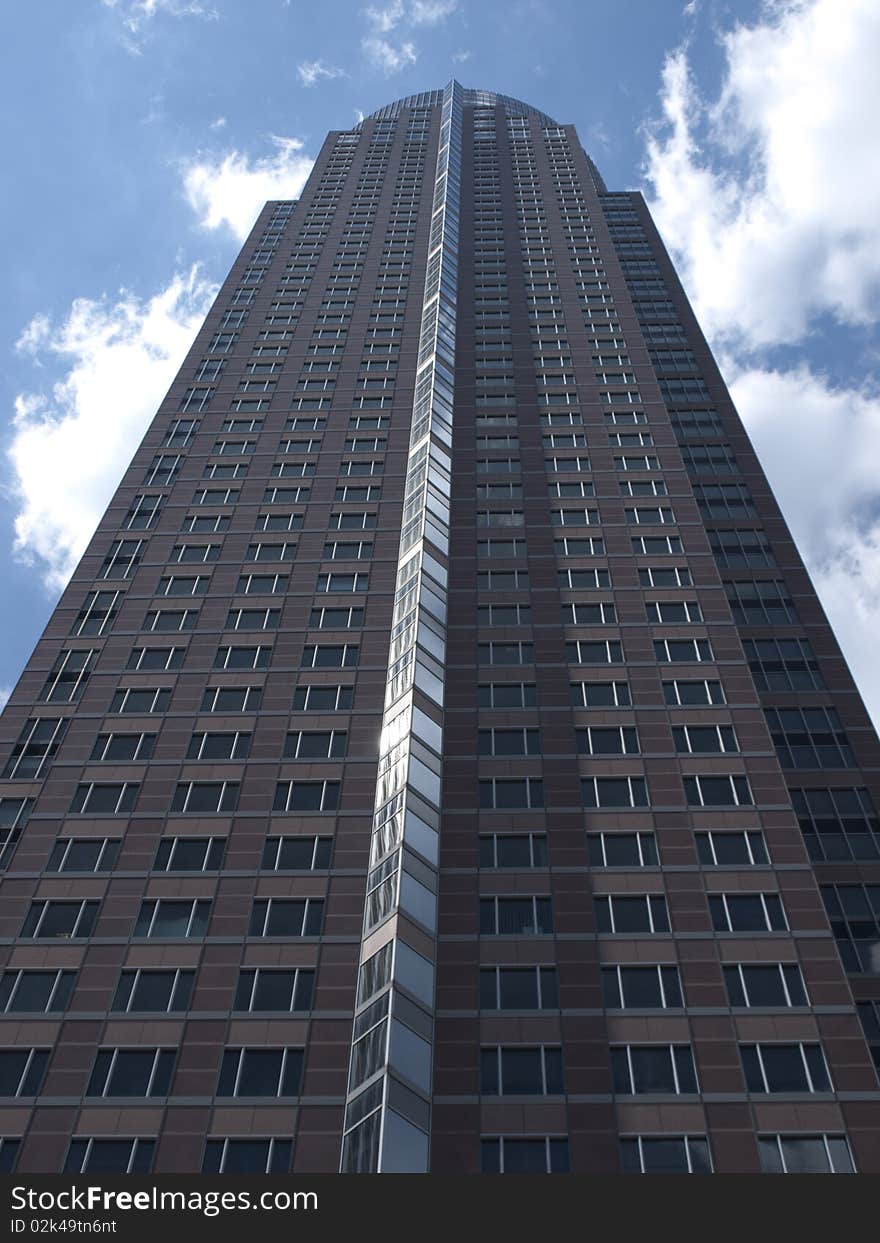 Messeturm in Franfkurt, modern corporate office building with scattered clouds in the background