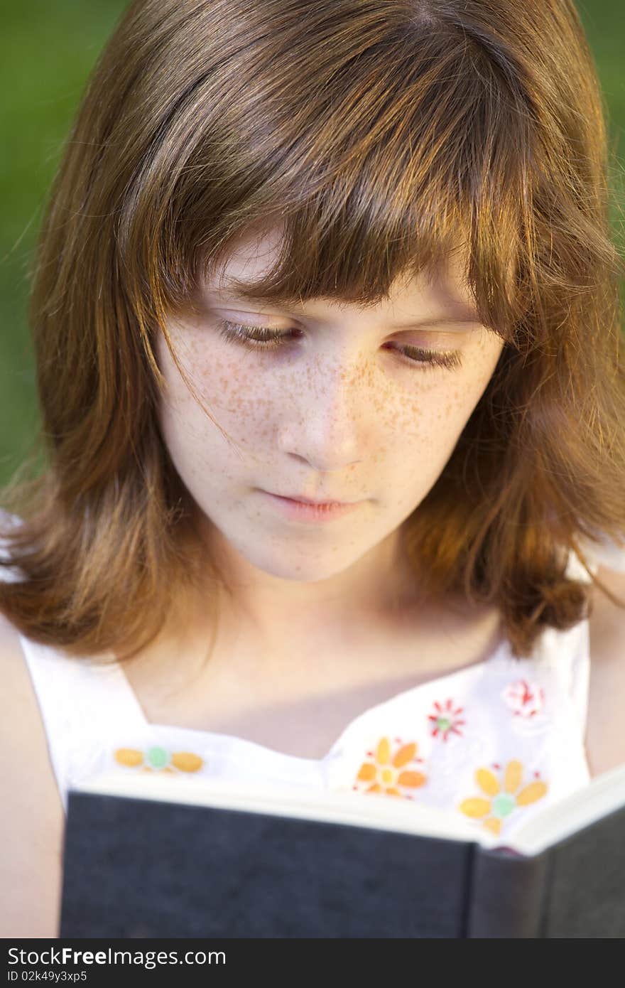 Young beautiful girl reading a book