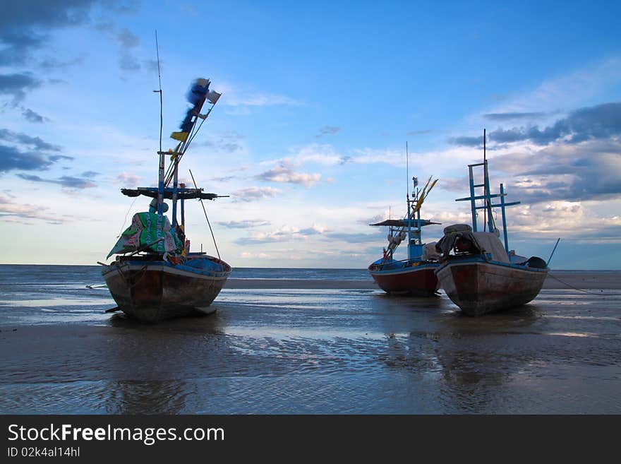 Three fishing boat rest on the beach