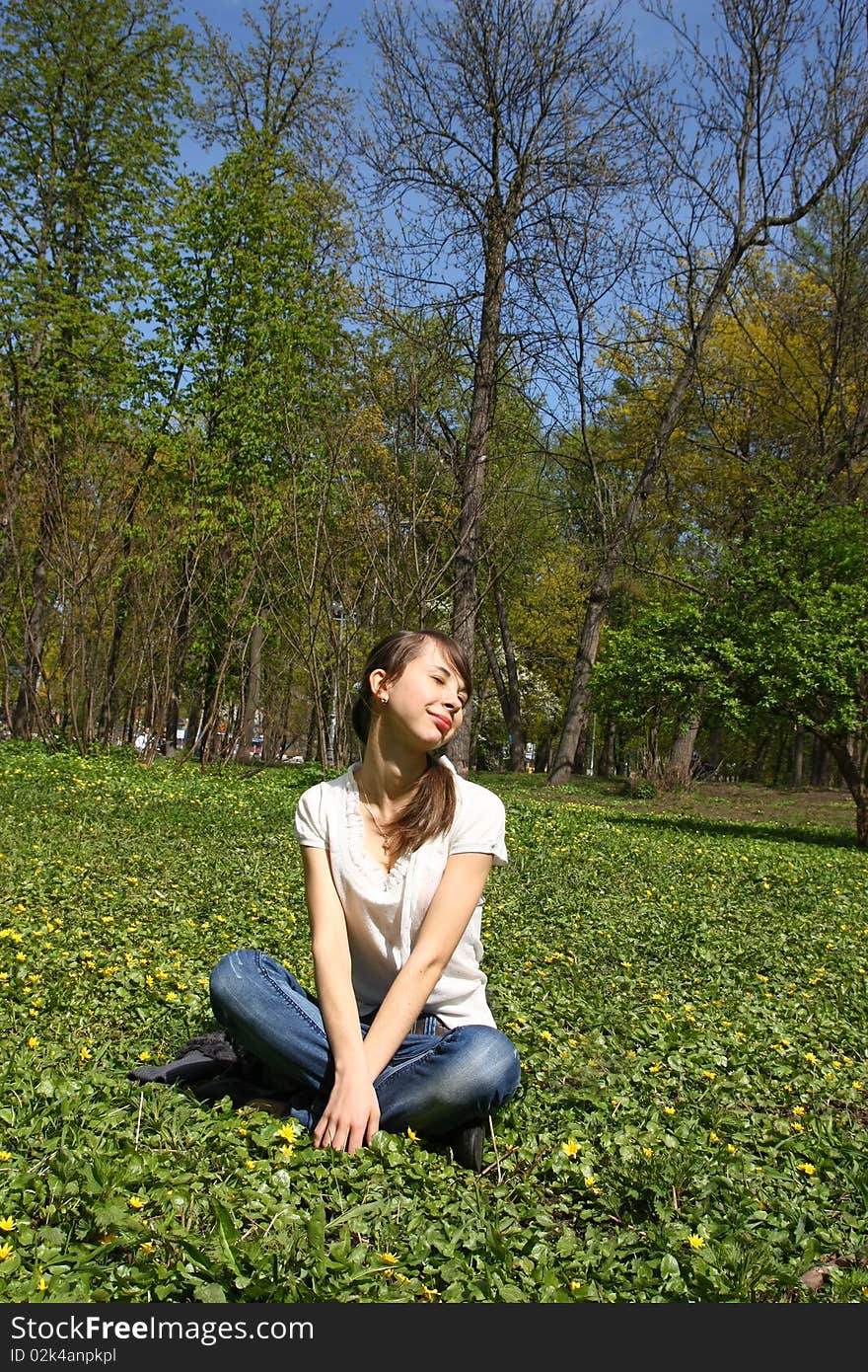 Girl sitting on the lawn in the park