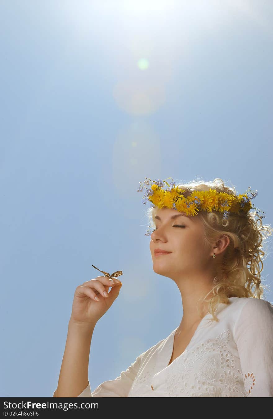 Lovely woman with a butterfly over blue sky