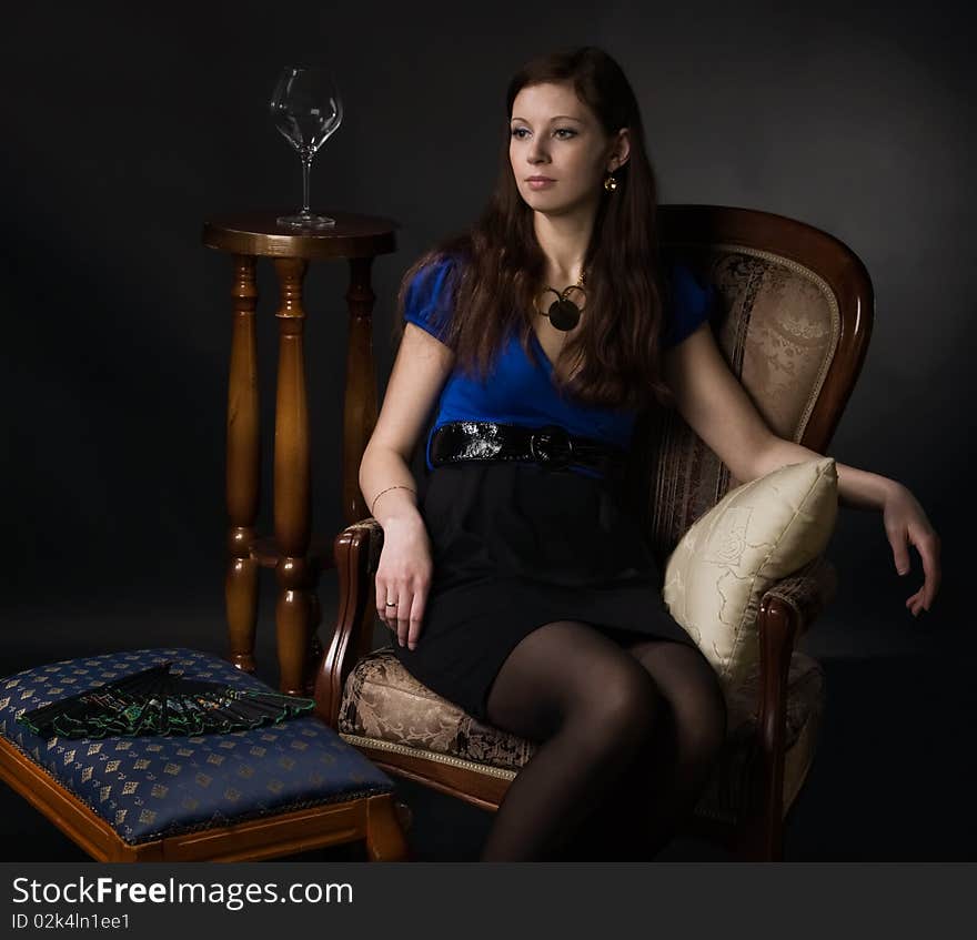 Beautiful young woman sits in a chair. Beautiful young woman sits in a chair