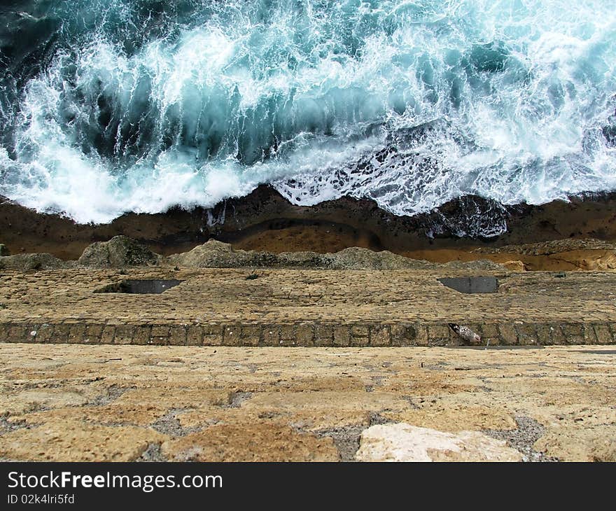 The sea and the yellow rocks of the neapolitan Castel dell'Ovo, in a eternous fighting. The sea and the yellow rocks of the neapolitan Castel dell'Ovo, in a eternous fighting