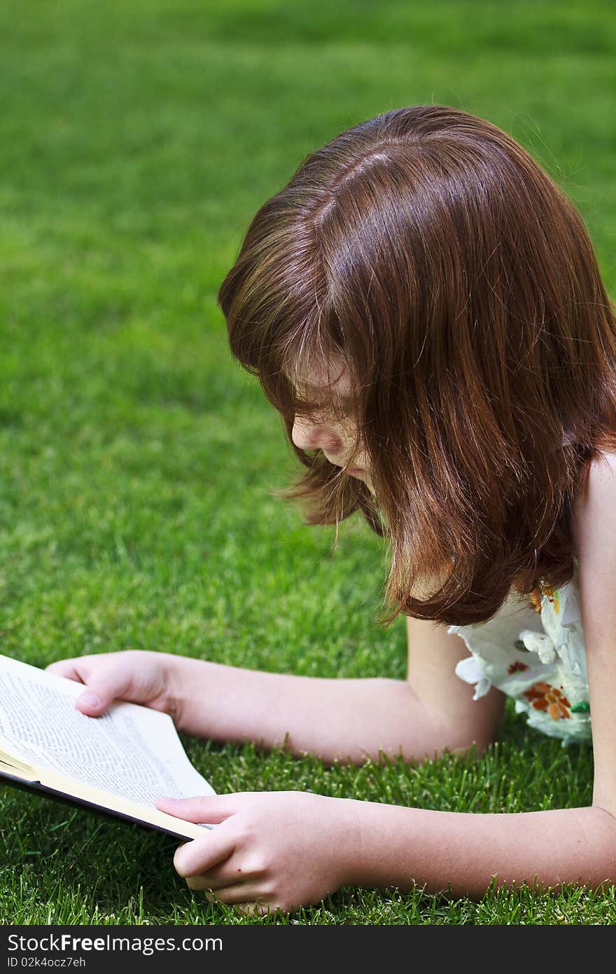 Young beautiful girl reading a book outdoor