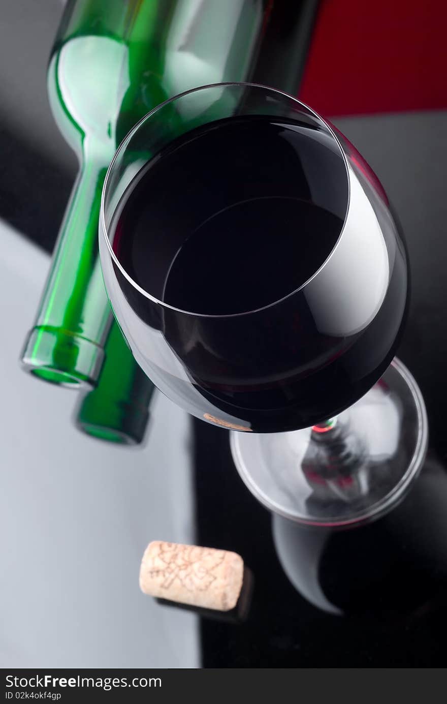 The top view of a glass of wine and bottle lying nearby. The top view of a glass of wine and bottle lying nearby