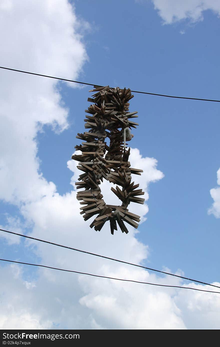 Old wooden clothespins hanging, in the background beautiful sky