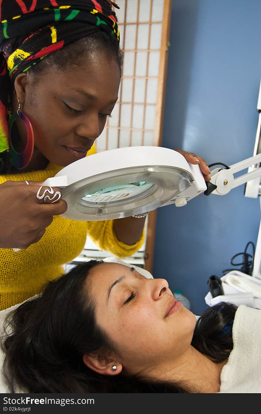 This is a makeup artist inspecting her clients skin for artifacts. This is a makeup artist inspecting her clients skin for artifacts.