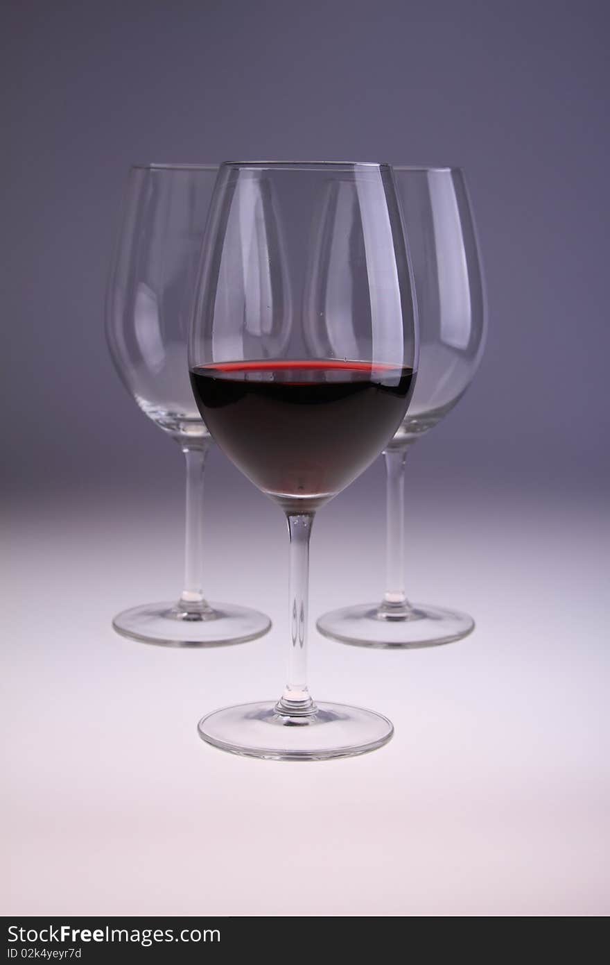 Image of wine glasses, one filled with red wine.