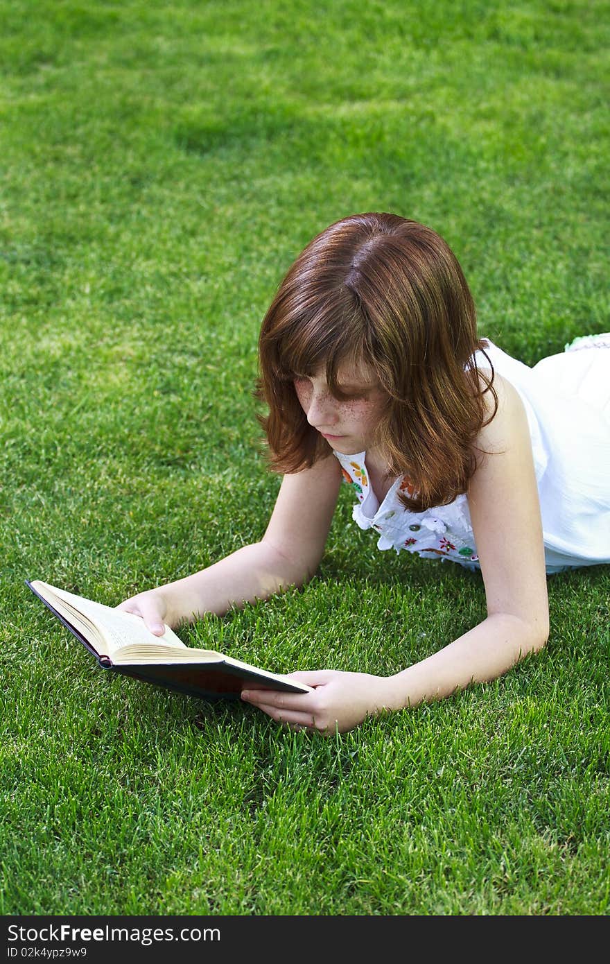 Young beautiful girl reading a book outdoor