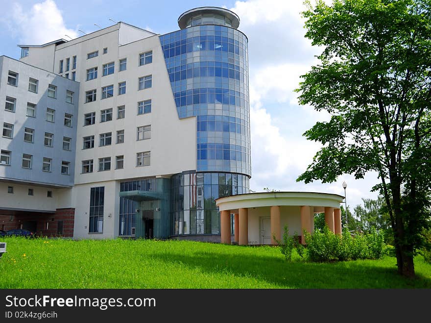 Modern office building against a lawn and the blue sky