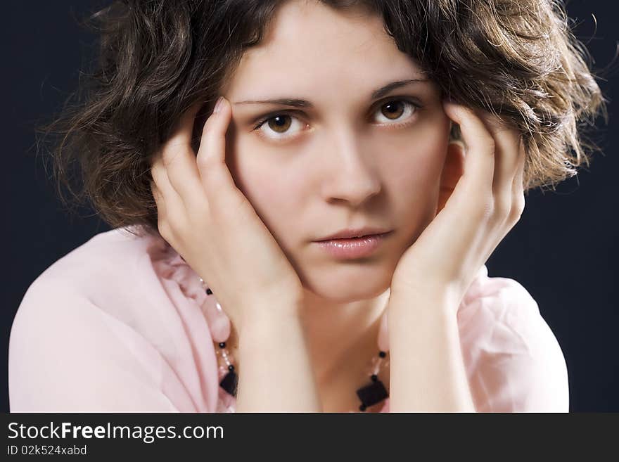 Portrait of a model sitting on black background with thoughtful look. Portrait of a model sitting on black background with thoughtful look.