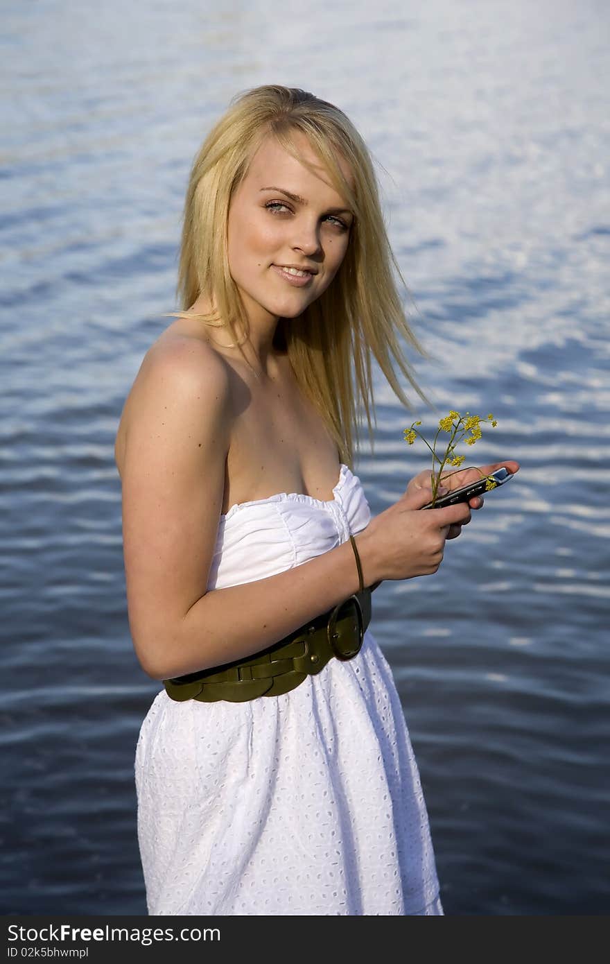 A woman by the water sending a text message. A woman by the water sending a text message.