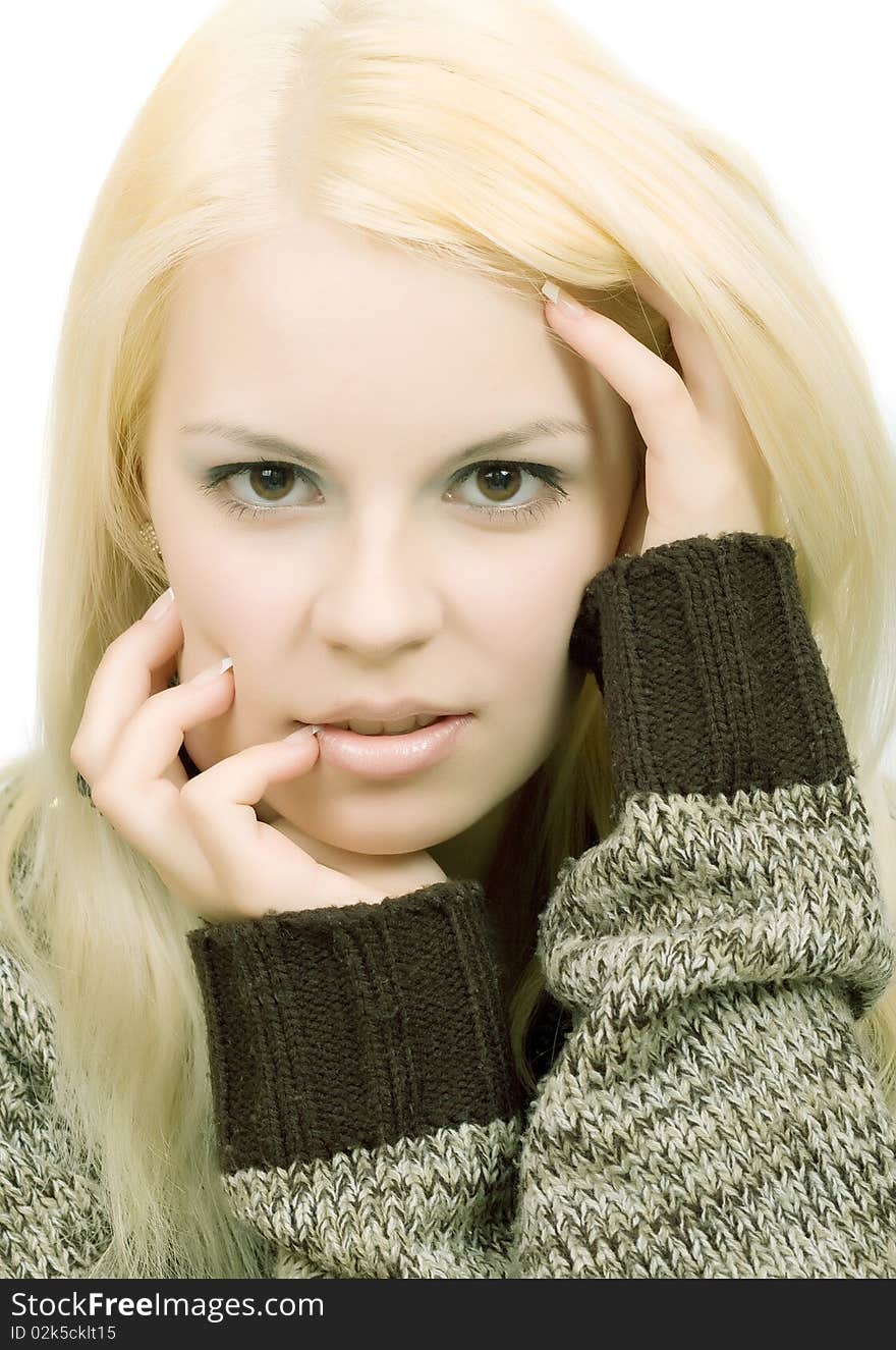 Young blonde woman in sweater with make-up on white background