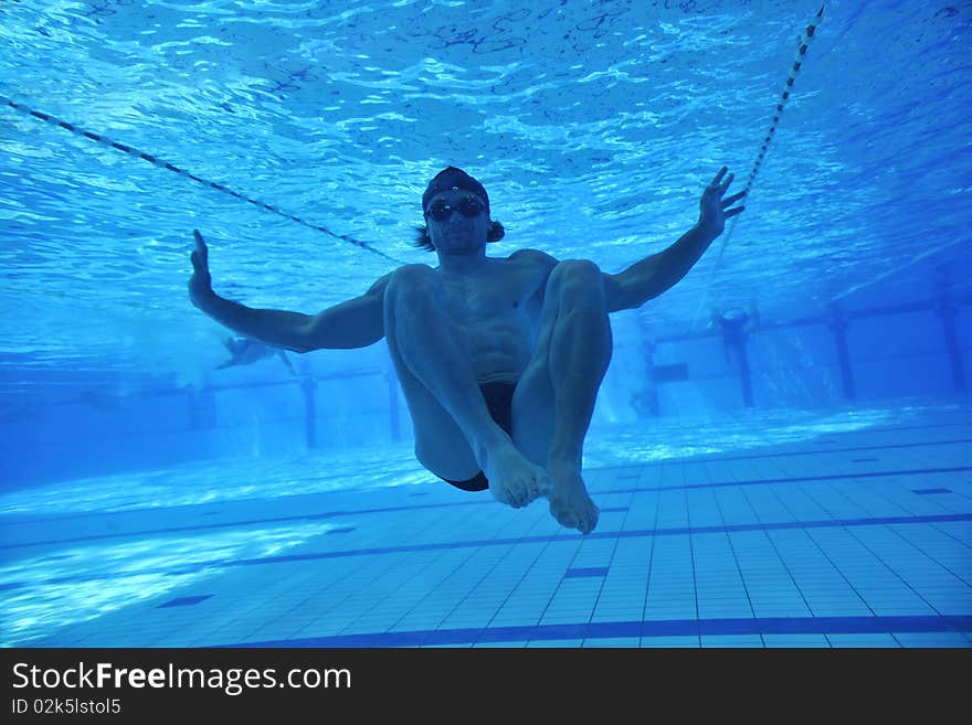 Undervater shoot of swimming pool with good looking young swimmer. Undervater shoot of swimming pool with good looking young swimmer