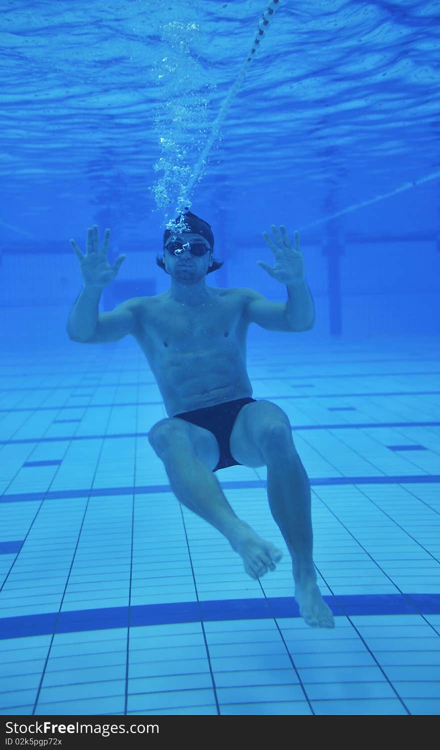 Undervater shoot of swimming pool with good looking young swimmer. Undervater shoot of swimming pool with good looking young swimmer