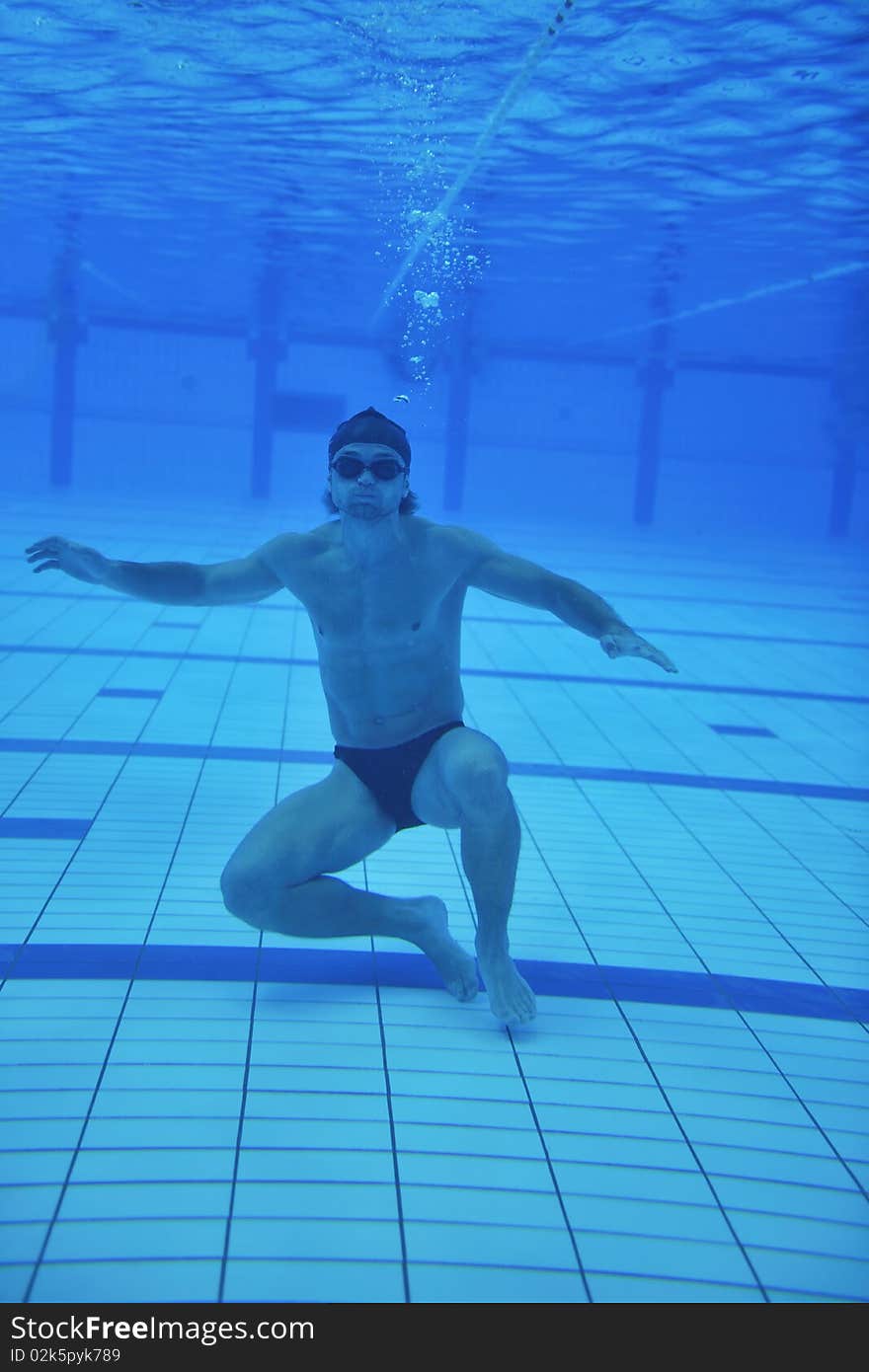 Undervater shoot of swimming pool with good looking young swimmer. Undervater shoot of swimming pool with good looking young swimmer