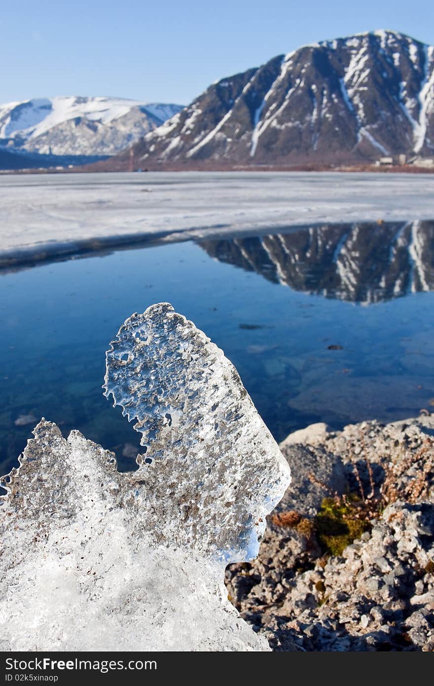 Big piece of ice on coast of lake in mountains. Big piece of ice on coast of lake in mountains