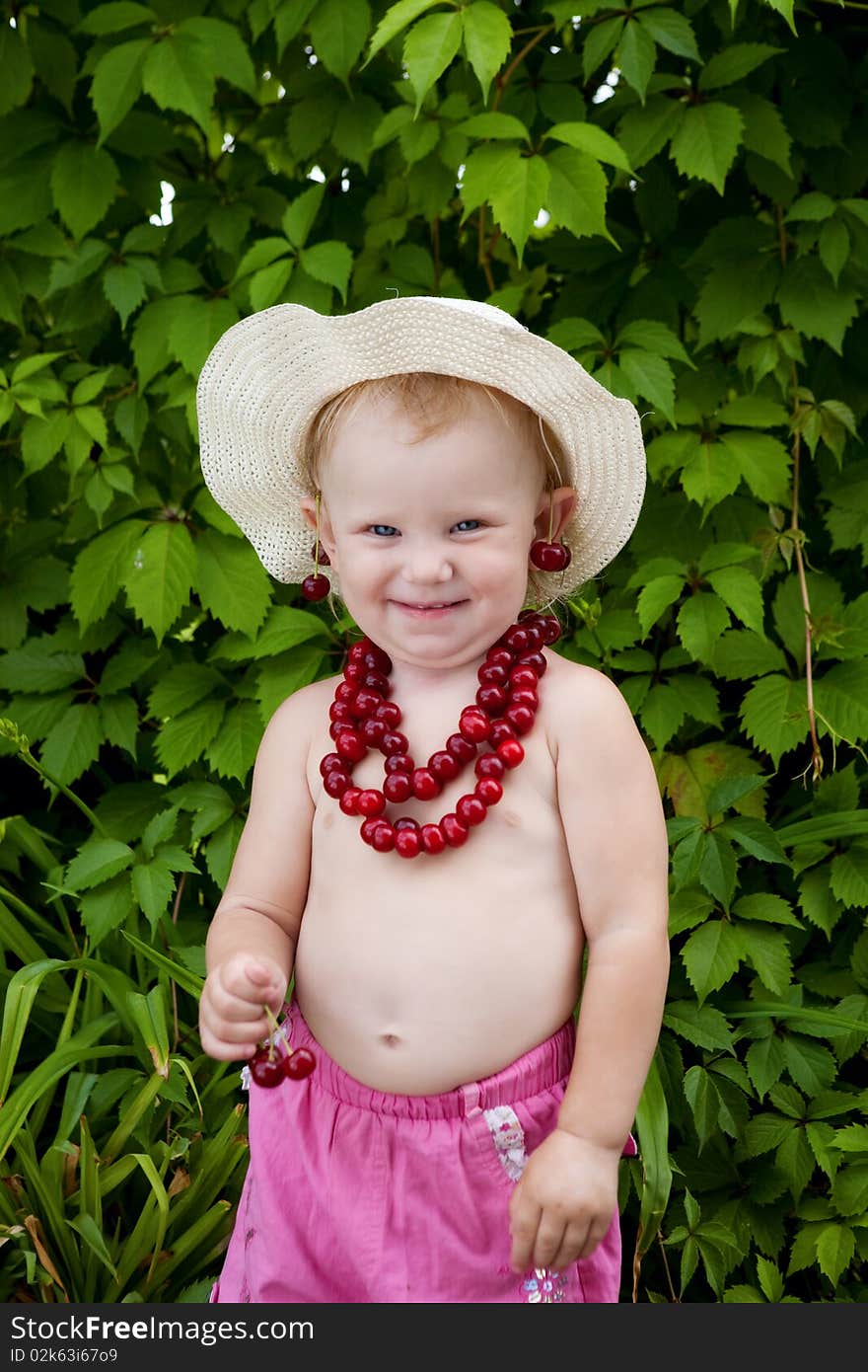 Girl and cherries in green leaves background