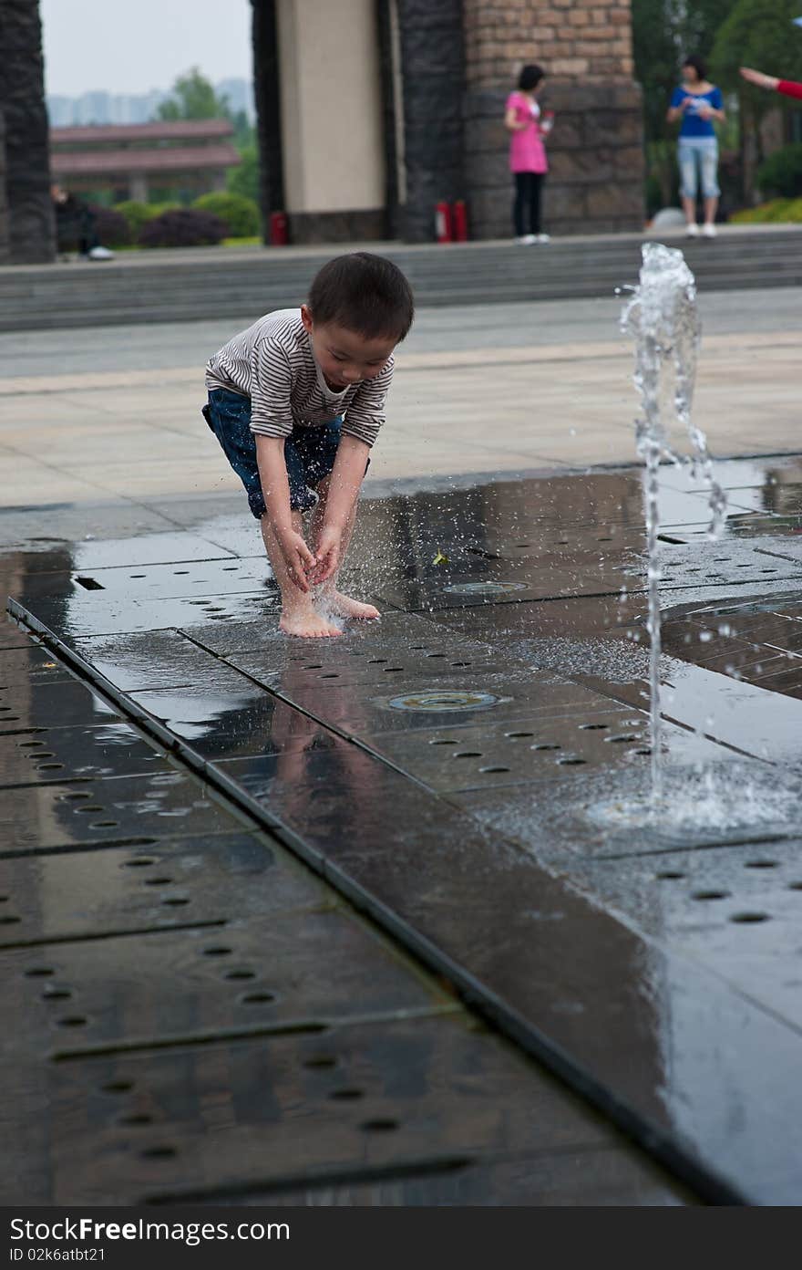 Happy asian boy play by Fountain