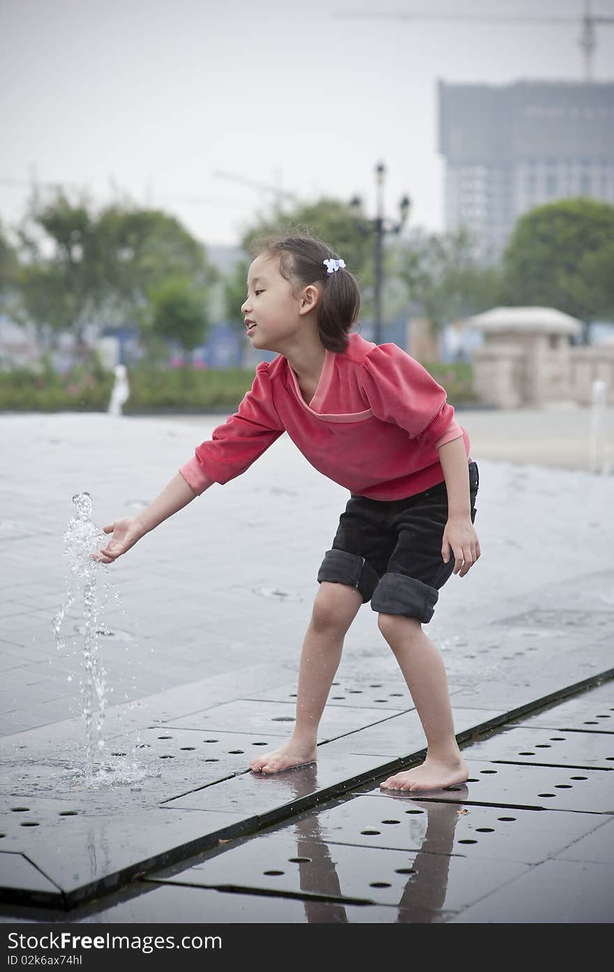 Happy asian girl play by Fountain