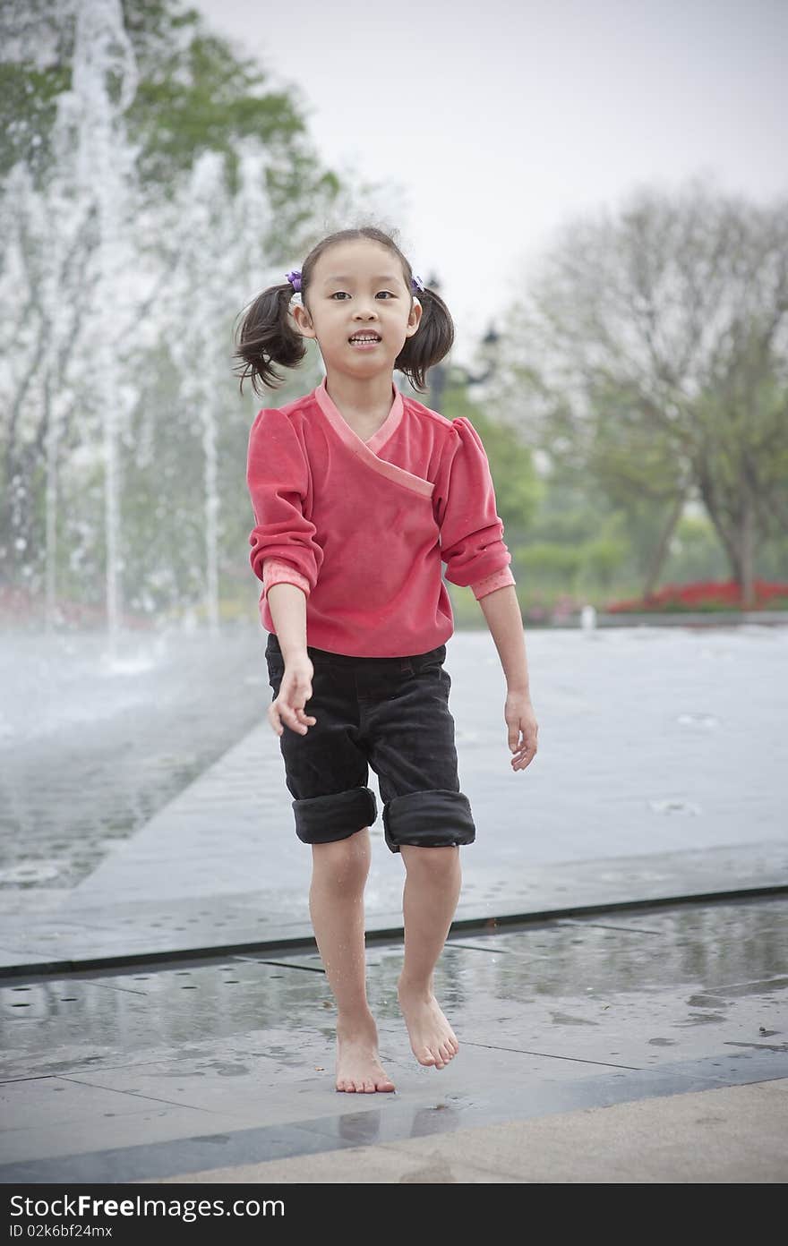 Happy asian girl play by Fountain