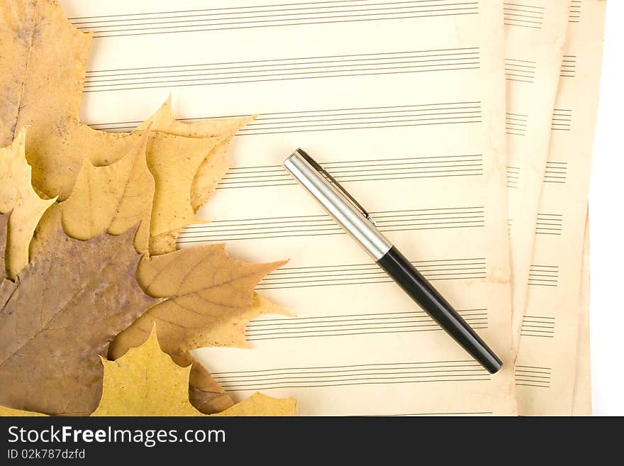 Old sheet music sheet of paper which has a handle and the autumn leaves of maple. Old sheet music sheet of paper which has a handle and the autumn leaves of maple