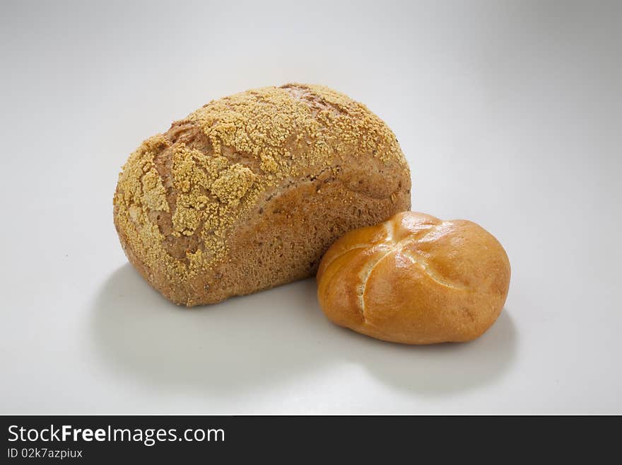 Loaf and a bum on a white surface. Loaf and a bum on a white surface