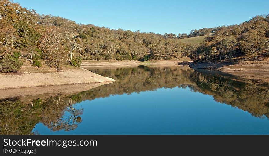 This is an early morning shot of a lake showing surface reflection. This is an early morning shot of a lake showing surface reflection.