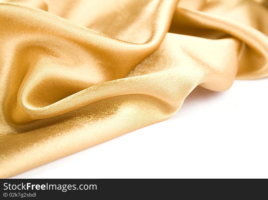 Luxurious gold satin folded cloth, useful for backgrounds. Isolated. Luxurious gold satin folded cloth, useful for backgrounds. Isolated