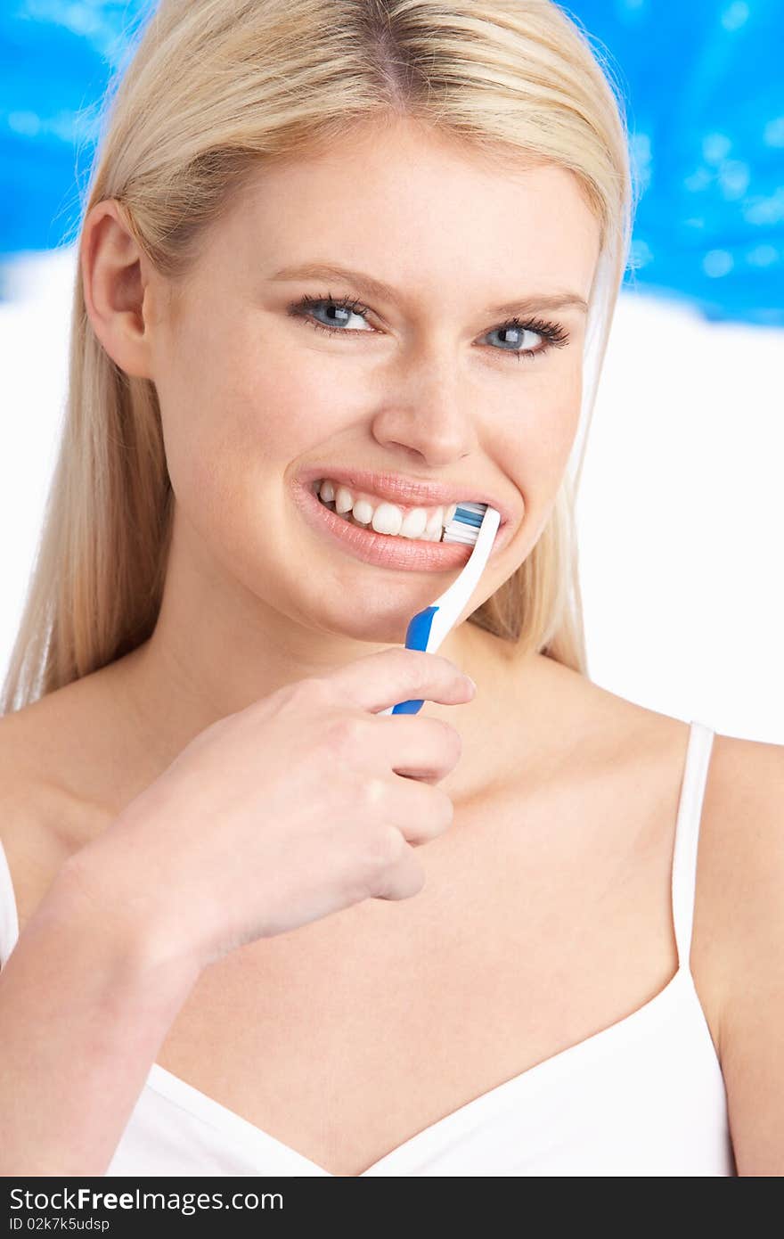 Young Woman Brushing Teeth In Studio At Camera