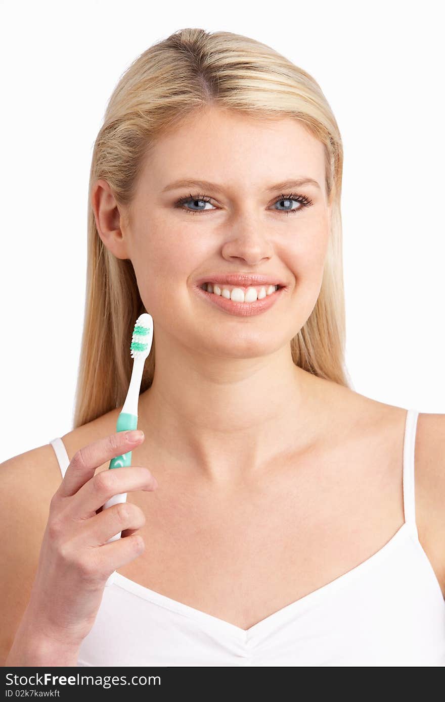 Young Woman Brushing Teeth In Studio At Camera