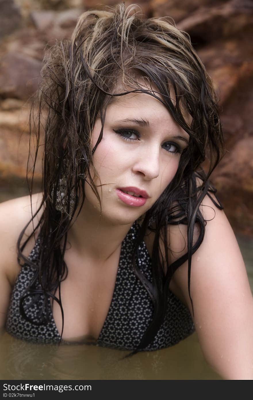 A beautiful woman in the water with wet hair.