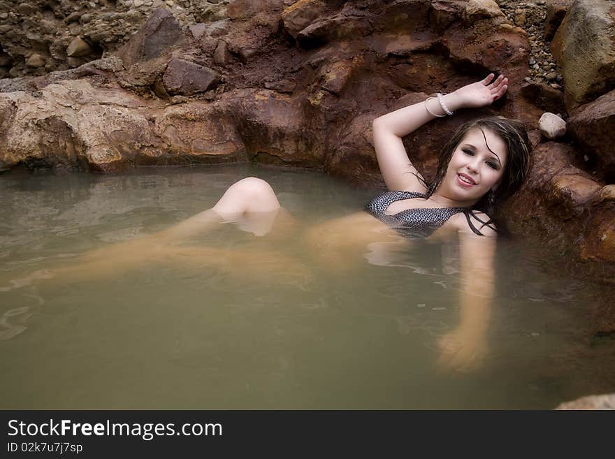 A woman is sitting in a pool with wet hair and relaxing. A woman is sitting in a pool with wet hair and relaxing.