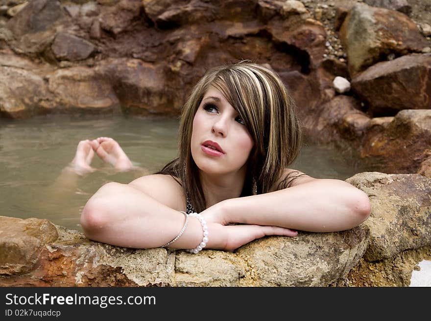 A woman is leaning on her arms in the pool and day dreaming. A woman is leaning on her arms in the pool and day dreaming.