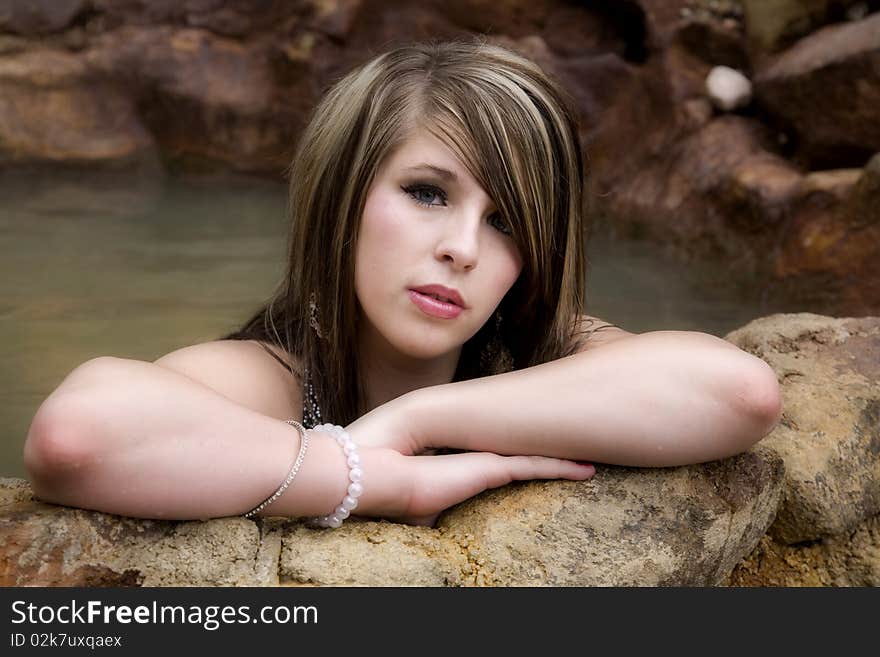 Woman in pool serious on arms