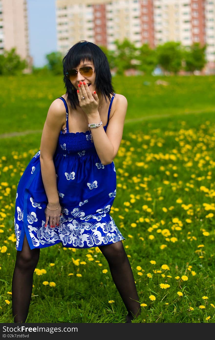 Summer girl in a blue dress against a background of green grass. Summer girl in a blue dress against a background of green grass