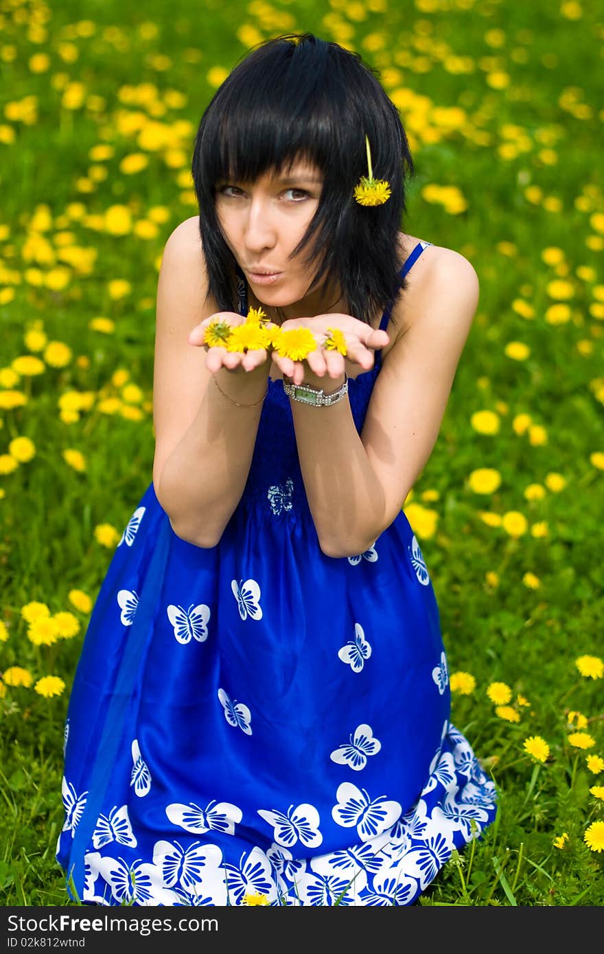 Summer girl in a blue dress against a background of green grass. Summer girl in a blue dress against a background of green grass